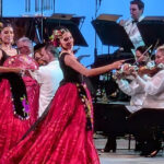 Con vestido rojo dos bailarinas del Ballet Folklórico de México